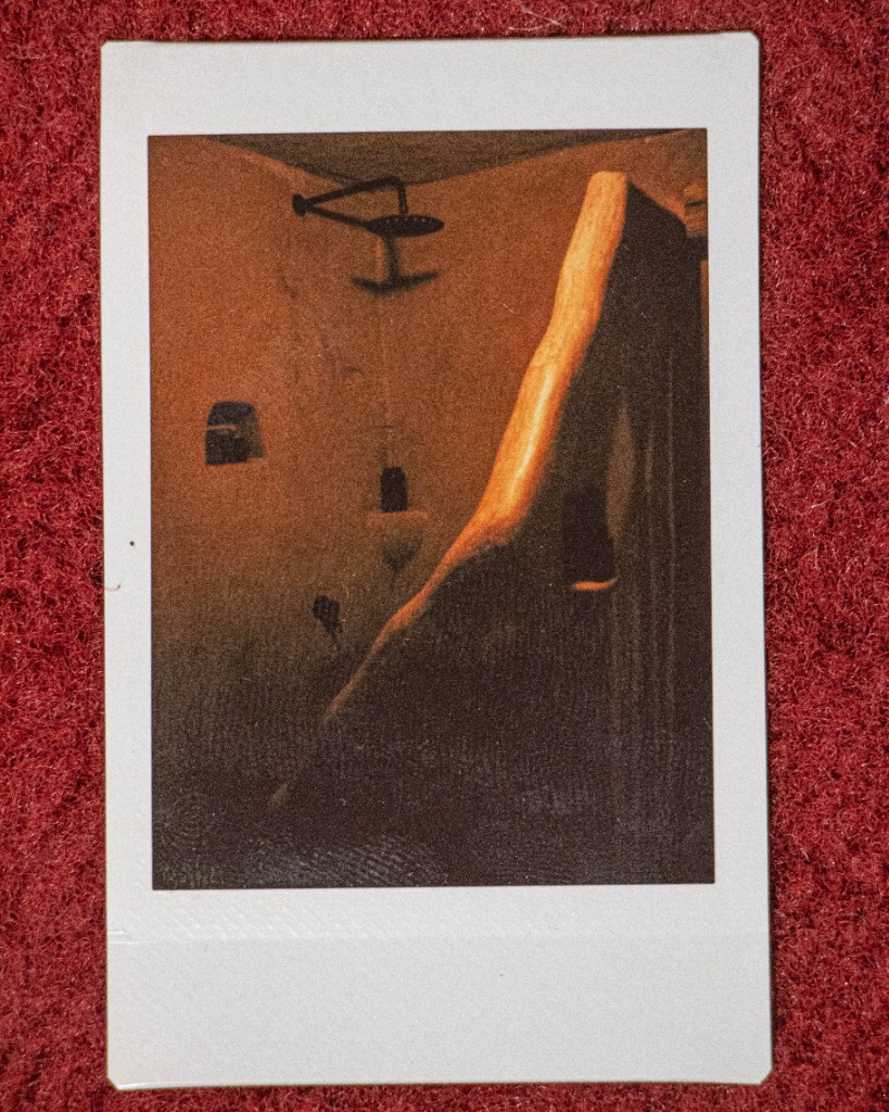 Polaroid of a rustic shower area